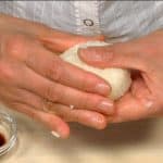 Và bây giờ chúng tôi sẽ làm cơm nắm onigiri xì dầu ngon! Làm ướt tay bạn bằng xì dầu và nặn chặt cơm thành hình tròn phẳng.