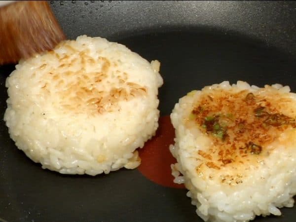 When lightly browned, flip them over. Coat the soy sauce onigiri with the extra soy sauce and sauté both sides until golden brown. The negi miso will burn easily so be careful not to overcook it.