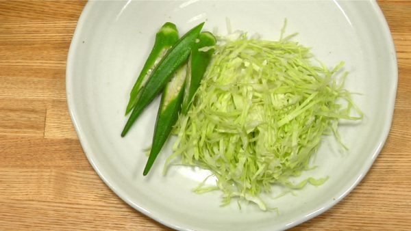 Cut the boiled okras diagonally and serve them next to the shredded cabbage.