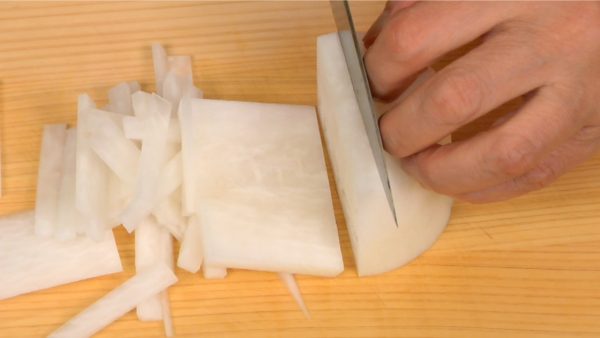 Cut the daikon into 5 mm (0.2") slices. Stack the slices and shred the radish into 4 cm (1.6") strips.