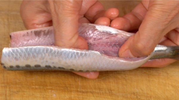 Now, let’s fillet the sardines. First, place your thumbs onto the backbone and open the sardines from side to side.