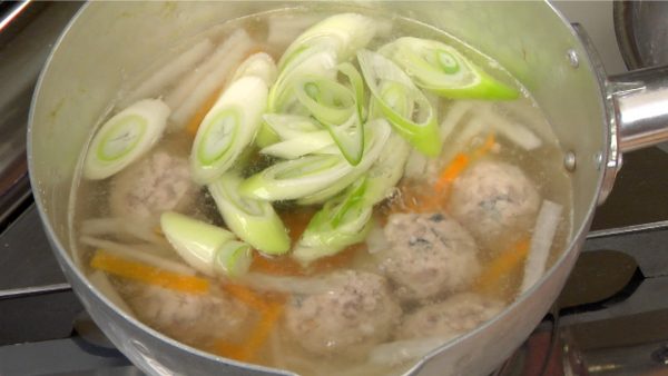 When the tsumire balls begin to float to the surface, drop in the long green onion and simmer for about 1 minute.