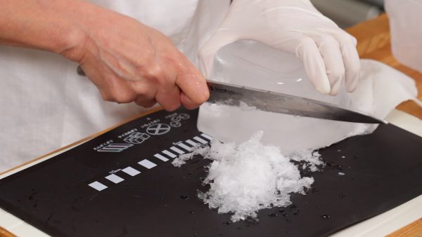 Portez des gants de cuisine pour tenir la glace fermement et râpez-la avec un couteau. Évitez d'utiliser un couteau cher car la lame peut être endommagée. Et n'utilisez jamais un couteau en céramique pour ça sinon il va se casser. 