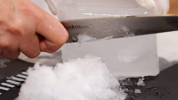 Gradually rotate the ice so that you can easily shave off the ice. Be careful not to cut yourself.
