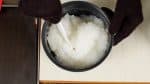 Mexa o arroz levemente com a colher de arroz e deixe-o esfriar até 60 °C (140 °F).