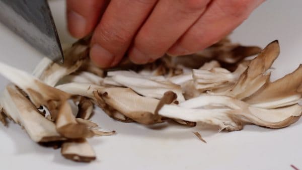 Tear apart the maitake mushrooms and trim into bite-size pieces with a knife.