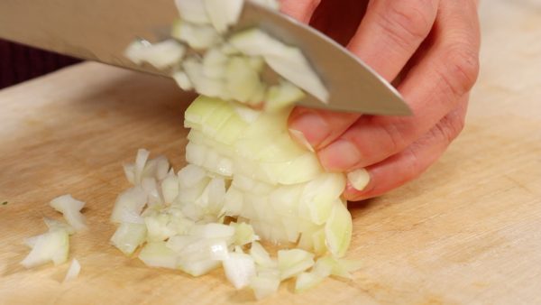 First, let’s cut the vegetables. Slice the onion along the grain with the root end attached. Rotate and slice it perpendicular to the initial cuts. Then, chop the onion into small pieces.