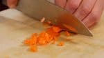 Coupez la carotte en lamelles fines. Ensuite, hachez-les en morceaux d'1 cm (0.4 inch). Réservez les oignons et les carottes dans un bol. 