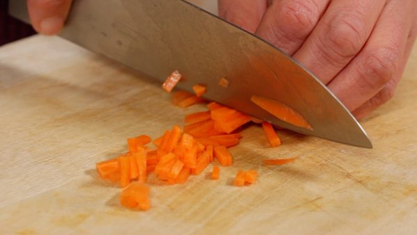 Slice the carrot into thin strips. Then, chop them into 1 cm (0.4") pieces. Reserve the onion and carrot in a bowl.