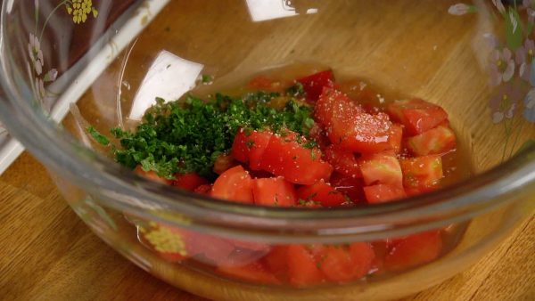 Add the tomato and chopped parsley leaves. Sprinkle on the salt and the pepper, and lightly mix the ingredients.