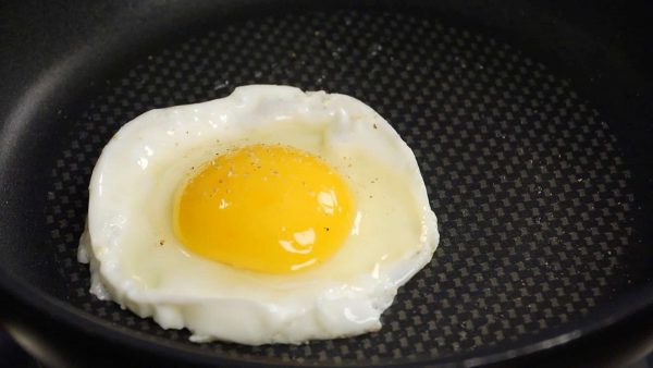 Tắt bếp trước khi lòng đỏ trứng cứng lại hoàn toàn. Bỏ khuôn trứng hình tròn ra.