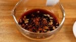 Ajoutez la gousse d'ail hachée et le ichimi, piment rouge. Et mélangez bien. 