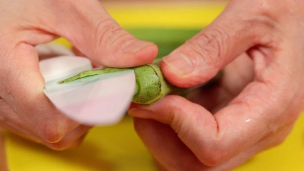 Next, remove the firm skin between the cap and the pod from the okra.