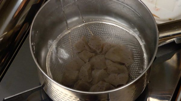Then, simmer the konjac in a pot for 1 to 2 minutes. This will reduce its distinctive smell and help it absorb the stock later. Remove the pieces with a mesh strainer.