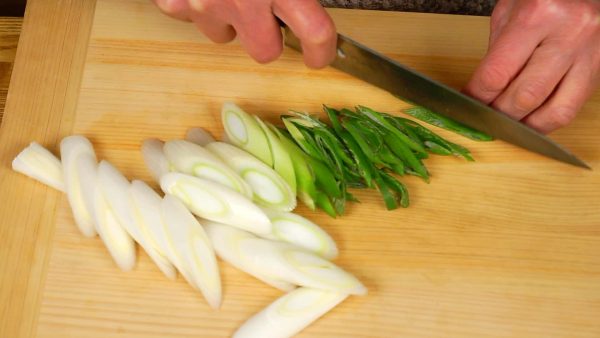 Slice the white part of the long green onion into 1cm (0.4") pieces using diagonal cuts. Then, slice the green part into thin strips.
