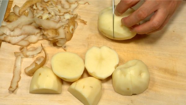 Let's cut the ingredients for korokke pan. Peel the potatoes. Remove the sprouts. Cut each potato into 2 or 3 pieces.