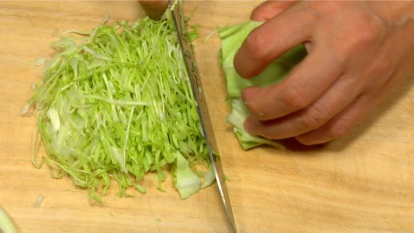 Remove the firm part of the cabbage. Stack the cabbage leaves and chop them into very fine strip.