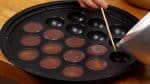 Likewise, pour the mixture over the candied beans and fill the rest of the takoyaki molds.