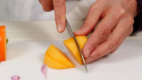 Ensuite, coupez le kaki persimon en quartiers épais d'1cm (0.4 inch) sur une planche à découper.