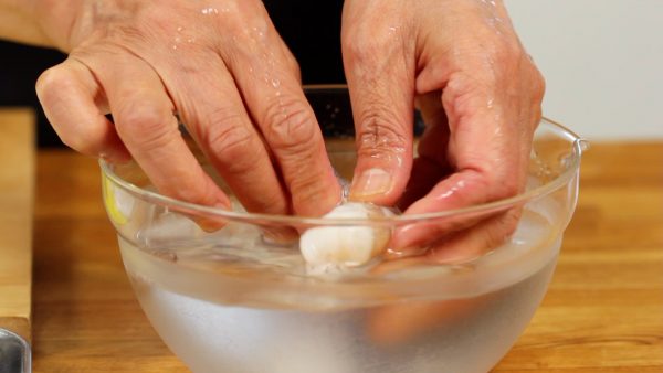Ajoutez une petite quantité de sel dans le bol d'eau froide. Dans notre précédente vidéo de tendon, les crevettes étaient mélangées avec du saké mais aujourd'hui nous les rinçons dans l'eau salée pour retirer les odeurs désagréables. 