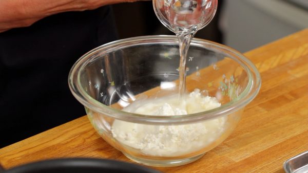 Let's make the batter for the tempura. Combine the tempura batter mix and water in a bowl.