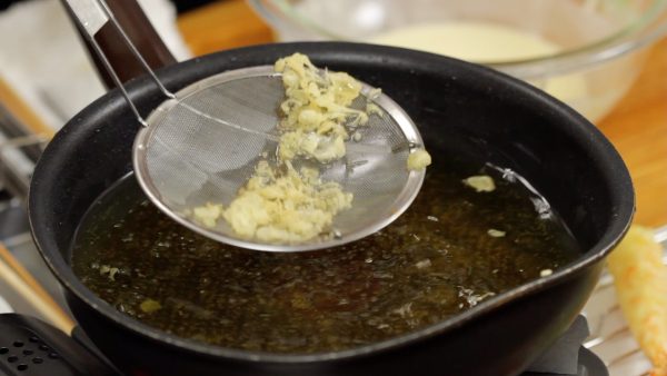 Remove the remaining tempura batter with a mesh strainer.