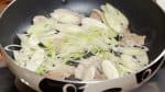 Then, add the long green onion and distribute it in the pan. Season with salt and pepper.