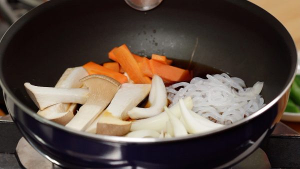 Ajoutez les nouilles shirataki, les oignons, les champignons king oyster et les carottes. 