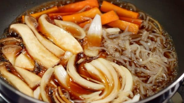 Immergez les ingrédients dans le bouillon et faites cuire jusqu'à ce que la carotte ramollisse. Vous pouvez aussi utiliser un poireau coupé en tranches en diagonale à la place de l'oignon.  