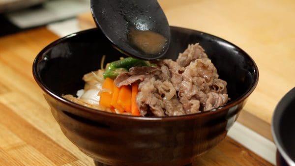 Cover the rest of the rice with a generous amount of the beef slices. Ladle a small amount of the broth over the beef.