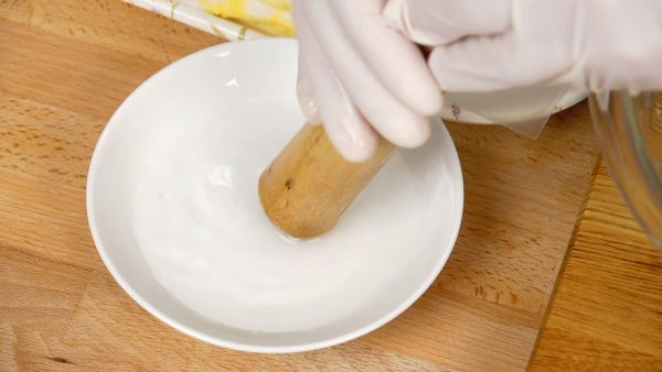 Bagna il pestello in legno con acqua leggermente salata e bagna anche l'interno di una ciotola per evitare che il mochi si attacchi.