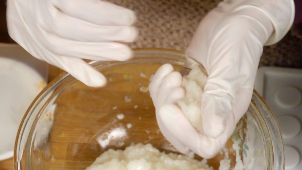 Next, wet your hand with the salt water and squeeze one of the large rice balls several time to make it easier to wrap the anko.