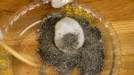 將飯糰i放在芝麻粉裡上並完全用芝麻粉來覆蓋。
