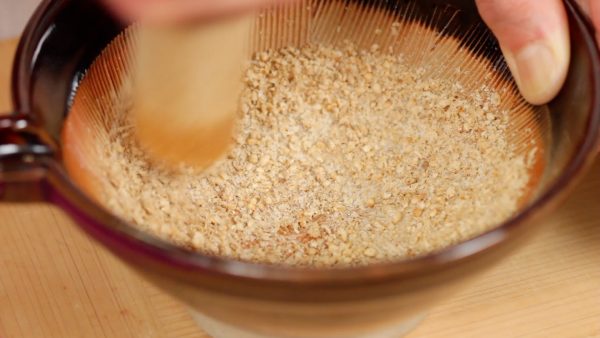First, let’s make the walnut miso paste. Place the sesame seeds into a suribachi mortar and grind the seeds until smooth.