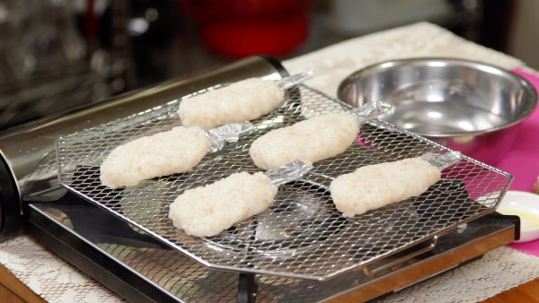 Lặp lại quy trình và để 5 miếng gohei-mochi lên giá nướng.