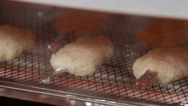 Now, place the mochi into a toaster oven. Heat the oven to 250 °C (480 °F) and grill the mochi for about 8 minutes until slightly browned.