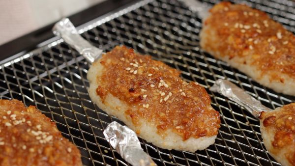 Remove the gohei-mochi. Then, sprinkle on the toasted sesame seeds and the sansho pepper powder.