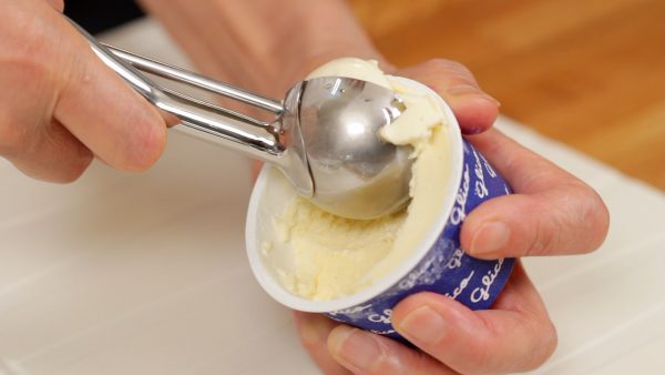 First, dampen an ice cream scoop and make the vanilla ice cream into a ball.
