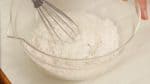 Agora, vamos fazer a massa de tempurá. Combine água gelada e farinha de trigo em uma tigela. Misture com um batedor balão.