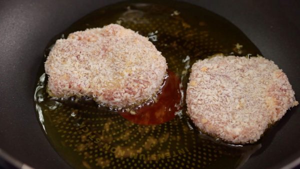 And now, let’s make the tonkatsu, deep-fried breaded pork. Heat a generous amount of vegetable oil in a pan and fry the breaded pork on medium heat.