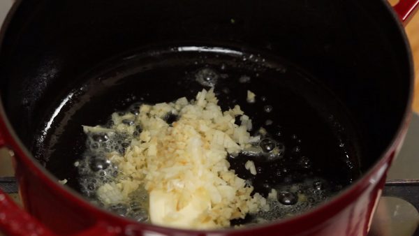 Next, add the butter to the pot. Add the chopped ginger root and garlic. Saute but avoid burning.