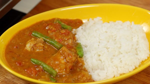Vierte el delicioso curry de pollo y yogur a un lado del arroz en un cuenco.