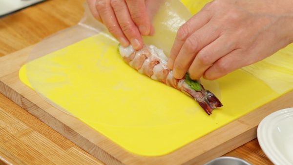 Place the prawn onto the center and tightly roll it in the rice paper.