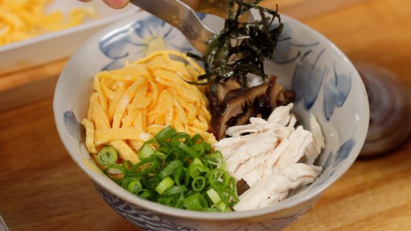 Và bây giờ, chúng tôi sẽ làm Keihan. Để cơm mới nấu vào bát và sắp xếp kinshi tamago (trứng rán thái sợi), fukumeni nấm hương (nấm hương đã bù nước hầm trong nước dùng), thịt gà và lá hành lá đã thái. Trang trí bằng rong biển Nori nướng thái sợi ở giữa.