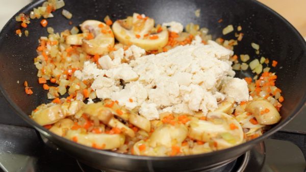 Lorsque l'huile est bien répartie dans le plat, ajoutez le tofu émietté.