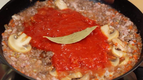 Después, añade la salsa de tomate de lata, la hoja de laurel y la sal.