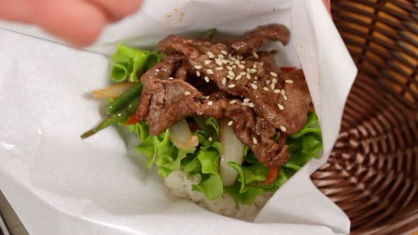 Add the green leaf lettuce, stir-fried vegetables and beef slices. Sprinkle on the toasted white sesame seeds.