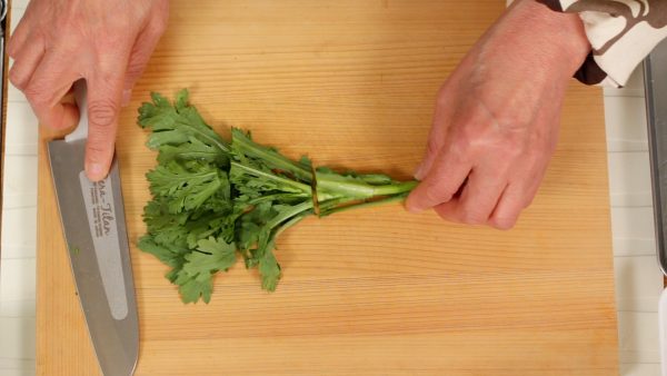 Clean the cutting board and cut the shungiku leaves into 4 cm (1.6") pieces.