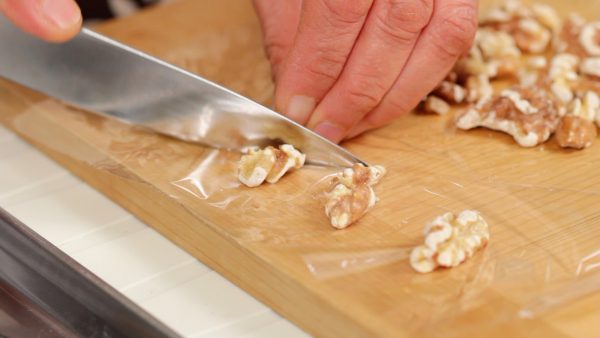 First, cut 4 walnuts in half. These walnuts will be placed in the filling later.