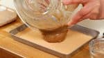 Et maintenant, placez le mochi sur un plateau couvert de kinako (farine de soja grillé). Le mochi est très collant donc veillez à utiliser une quantité généreuse de farine de soja. 